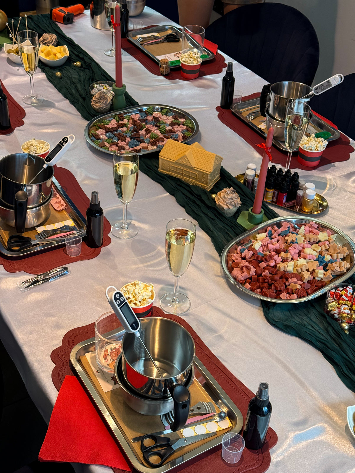 Festive candle-making workshop setup in Vienna with wax melting pots, candle-making tools, fragrances, decorations and Christmas table decor.